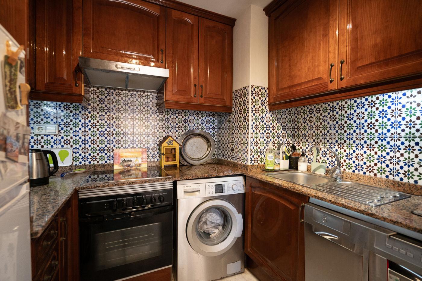 Kitchen with wooden units and patterned tiles